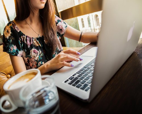 A person working in a modern Bangkok office with coffee and papers