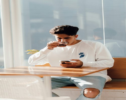 A person sitting at a cafe table enjoying a balanced breakfast with sunlight