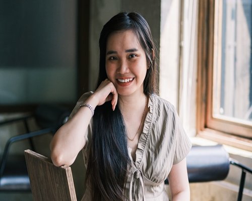Portrait of a smiling asian woman writing in a journal